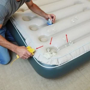 A person applying soapy water with a sponge or spray bottle