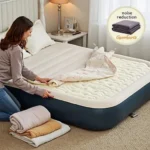 A person placing a mattress topper beneath the mattress